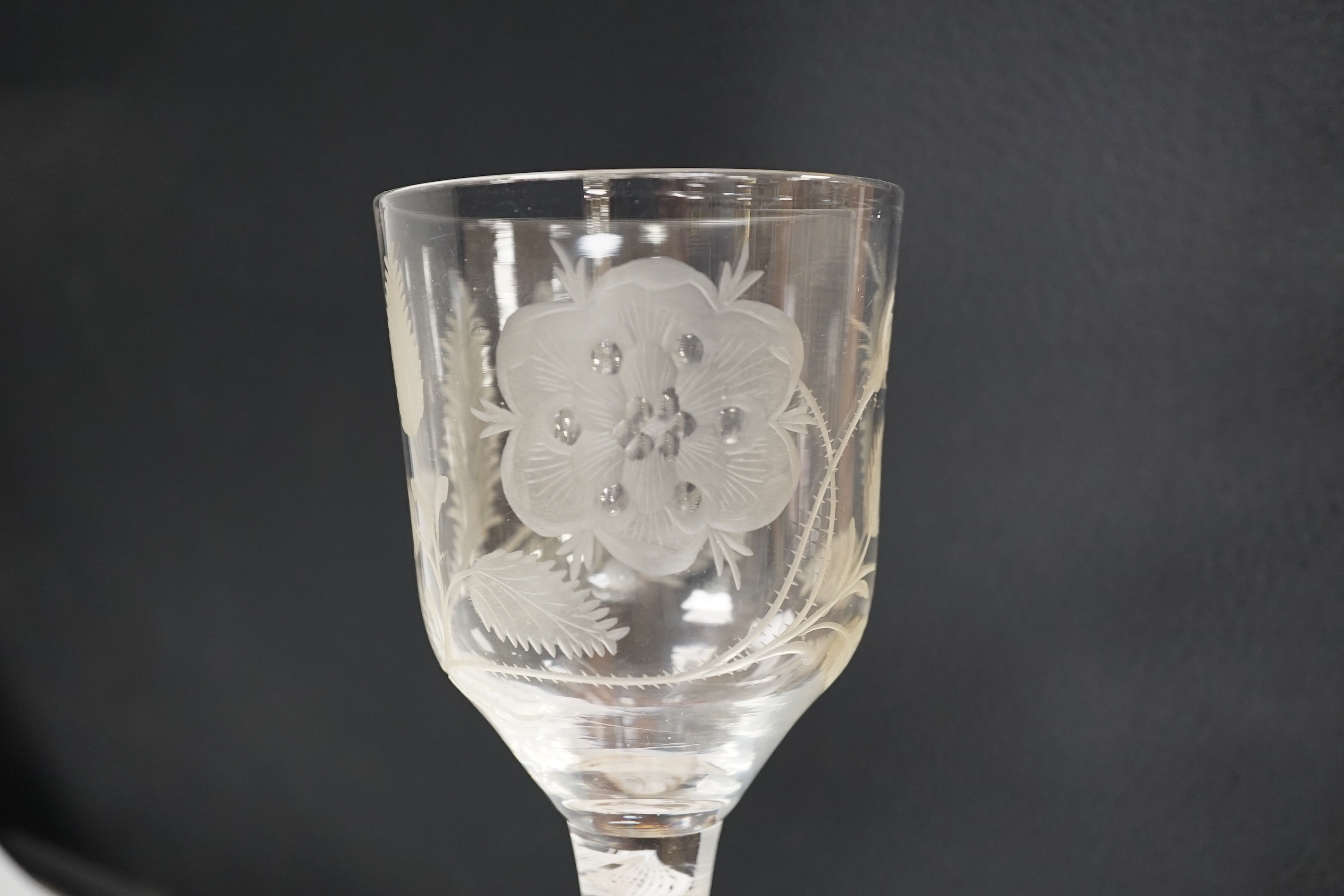 An English lead crystal Jacobite goblet, c.1750-60, bowl of ogee form, engraved with open and one closed rose and thistle, DSOT stem and plain foot with rough pontil, central gauze and multi spiral threads, tool marked,